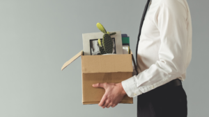 A man holding a box full of his office supplies.